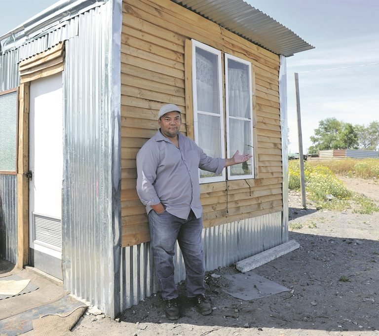 Quinton Adams by ‘n shack wat sy span gebou het. Foto: Netwerk24