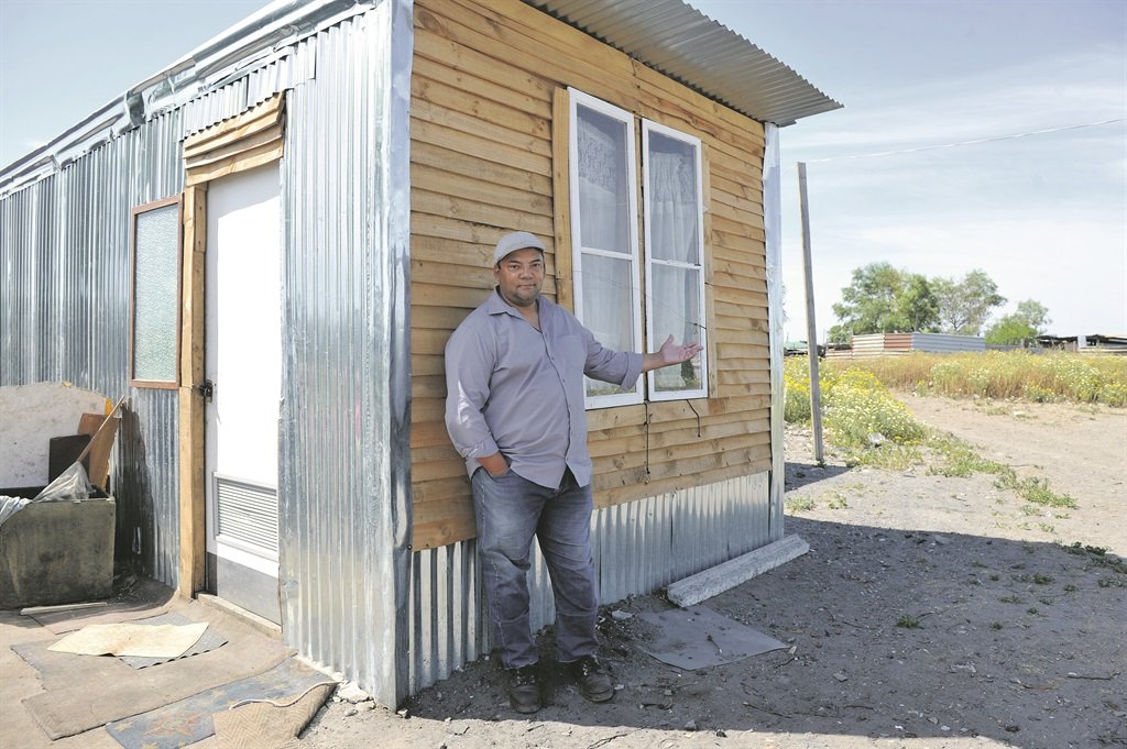 Quinton Adams by ‘n shack wat sy span gebou het. Foto: Netwerk24